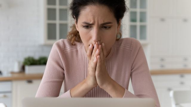 Mujer con cara de preocupación delante del computador