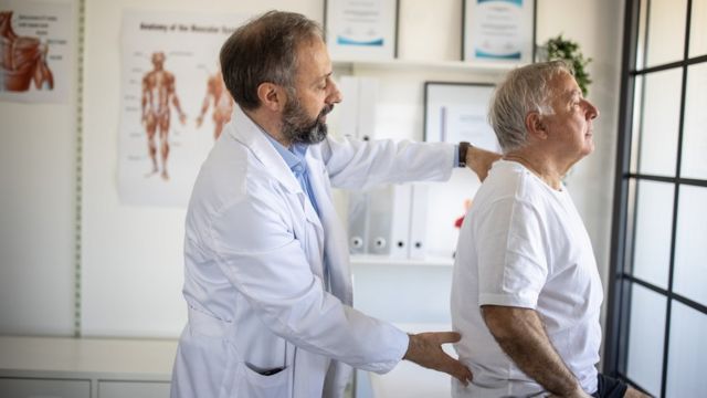 Un médico examina la postura de un paciente