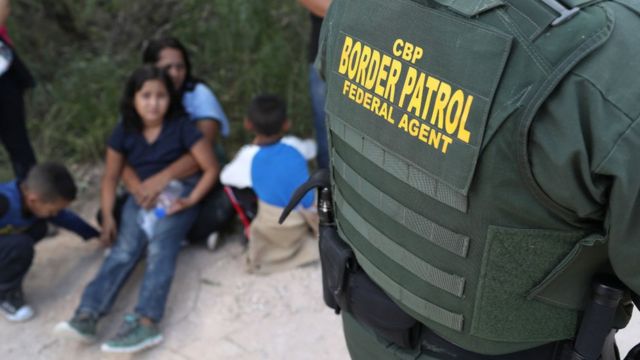 Agente de fronteira com imigrantes