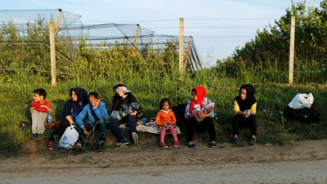A group of migrants rest on the Serbian side of the border near Sid, 16 September 2015.