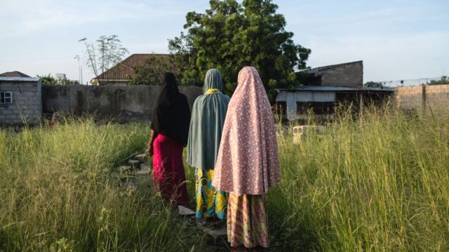 Três meninas voltam para casa em Maiduguri, Nigéria, a um campo para pessoas desabrigadas, 2019