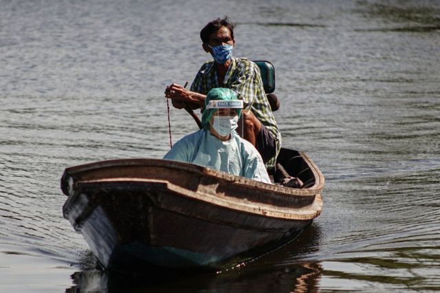 ชาวบ้านขับเรือพาเจ้าหน้าที่เข้าไปตรวจหาเชื้อชาวบ้านในชุมชนริมน้ำ จ.สมุทรสาคร