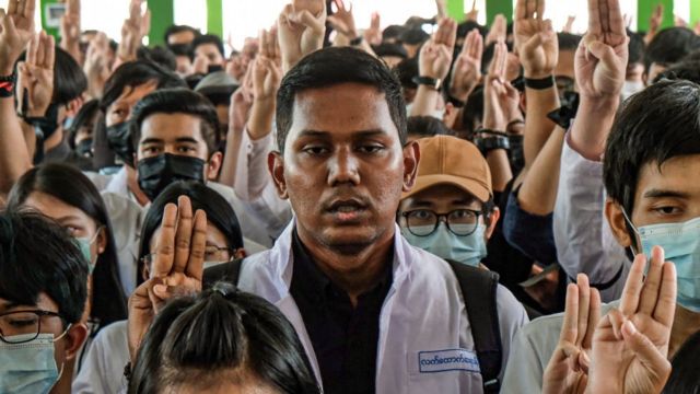 Medical students hold up the three finger salute at the funeral of Khant Nyar Hein in Yangon, Myanmar on March 16, 2021