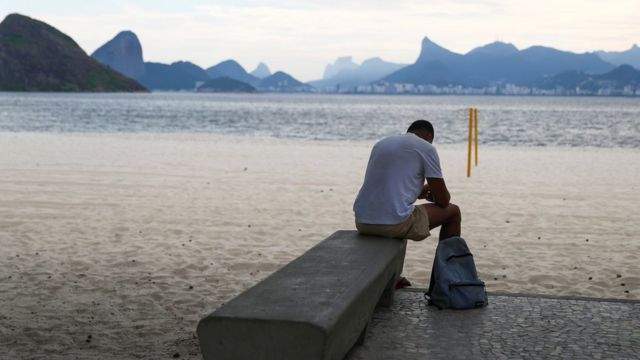 Hombre sentado en la playa de Icarai, Brasil