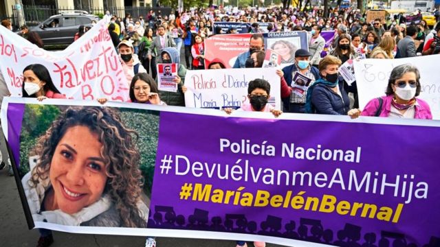 Protesters carry a banner with the face of María Belén Bernal.