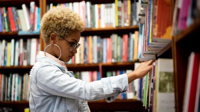 Jovem negra em uma biblioteca