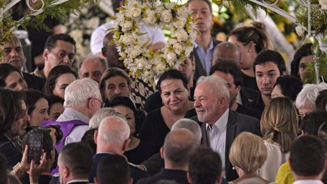 El presidente de Brasil, Luiz Inácio Lula da Silva, rodeado de personas en el funeral.