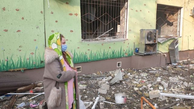 Uma mulher grávida do lado de fora de um hospital destruído em Mariupol