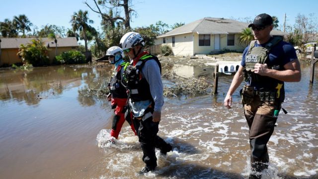 Rescatistas caminan por las inundadas calles de Fort Myers.