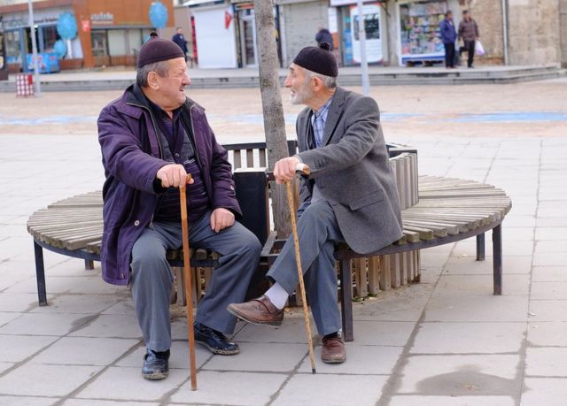 Two people sit on a bench to have a conversation