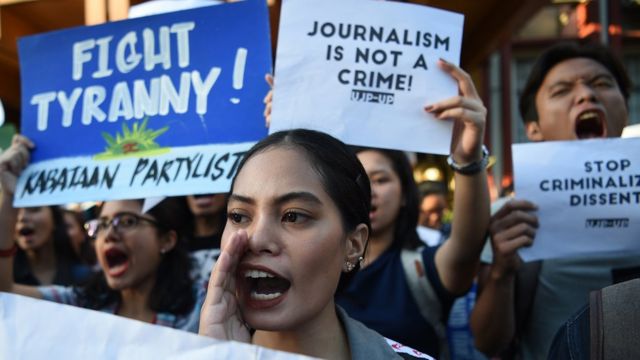 Filipino students hold placards as they shout slogans during a protest.