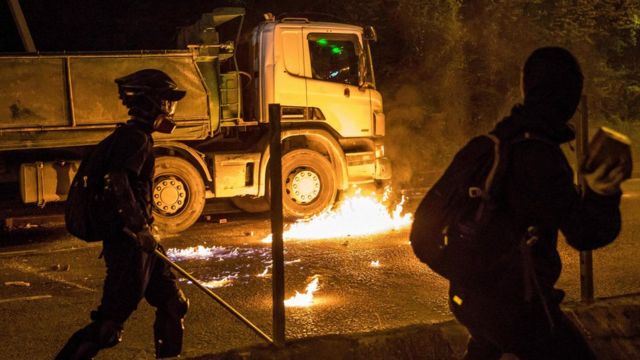 A petrol bomb thrown by a protester burns next to a truck after the driver attempted to drive through a blocked road outside the Hong Kong Polytechnic University on 14 November, 2019.