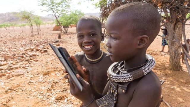 أطفال من قبائل أفريقيا يلعبون بهاتف محمول
