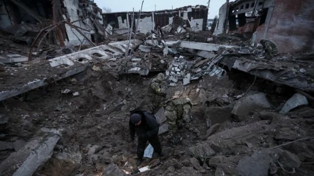 A polícia e os investigadores inspecionam uma cratera em uma área industrial destruída por um ataque de míssil russo, em meio ao ataque da Rússia à Ucrânia, em Kharkiv, Ucrânia, 15 de dezembro de 2022