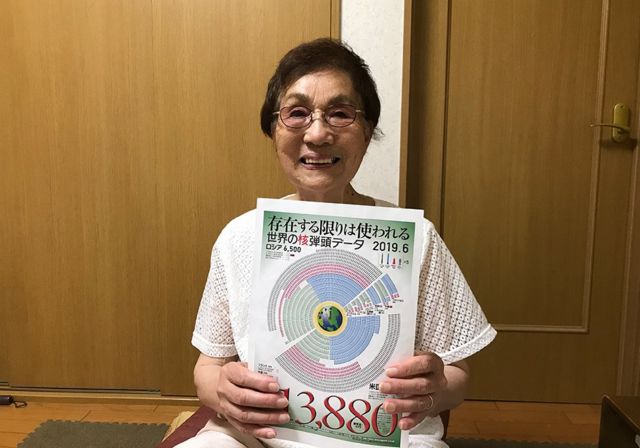 An elderly lady holds up a diagram to the camera