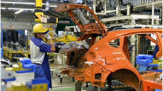 スバルの工場でバッテリーを搭載する作業員