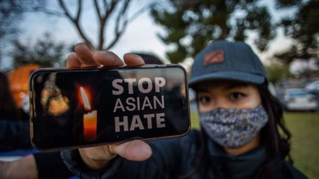 Julie Tran holds her phone during a candlelight vigil in Garden Grove, California, on March 17, 2021 to unite against the recent spate of violence targeting Asians