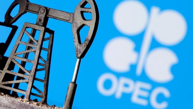 A 3D printed oil pump jack is seen in front of the OPEC logo (April 14, 2020).