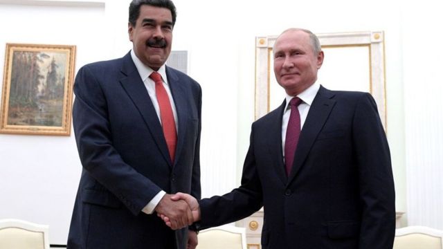 Nicolás Maduro and Vladimir Putin shake hands.