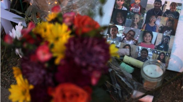 شموع وزهور أمام صور ضحايا الهجوم على مدرسة روب الايتدائية من الأطفال.