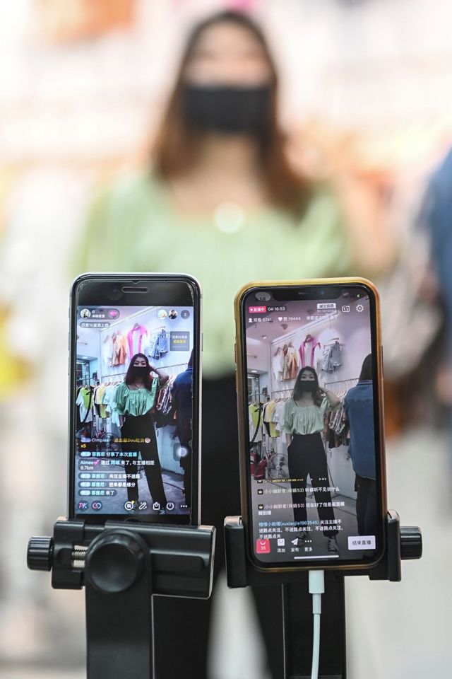 An anchor of a clothing store in Guangzhou is selling merchandise through live streaming.