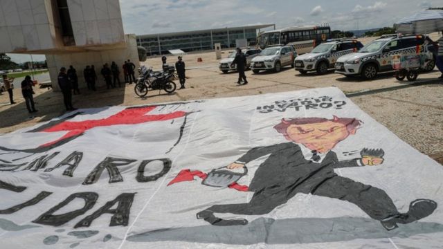 Bandeira com desenho de Bolsonaro ao lado de suástica nazista