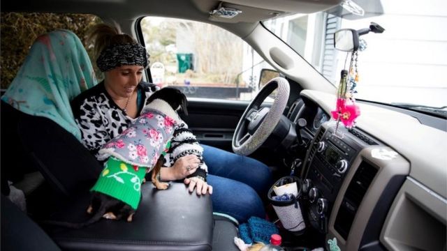 Laramie White, whose home was among the thousands in the city that were left without power after extremely cold weather moved through Texas earlier in the week, stays warm with her dogs in her truck in Corpus Christi, Texas, U.S. February 16, 2021