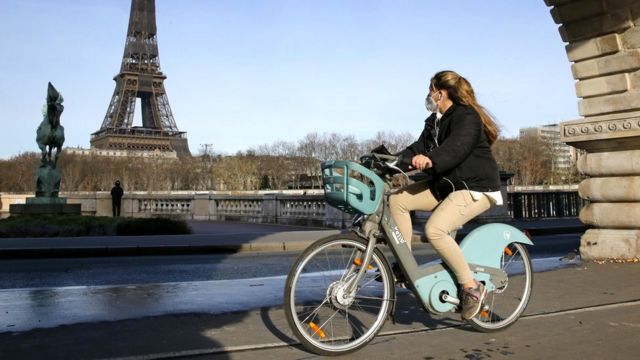 A woman rides a bicycle in Paris