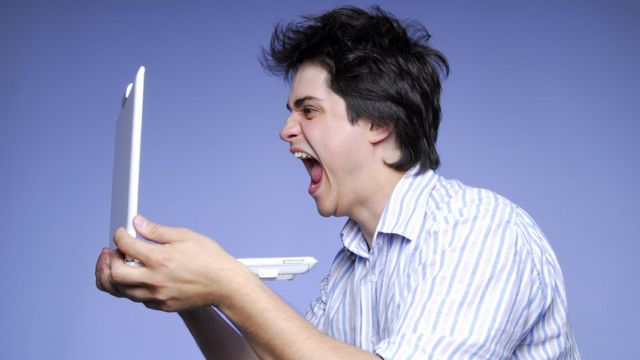 Hombre gritando a una computadora