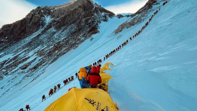 2001年，登山者在攀登珠穆朗玛峰的一个斜坡时排起了长队。(photo:BBC)