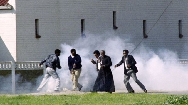 Desmond Tutu in a cloud of tear gas