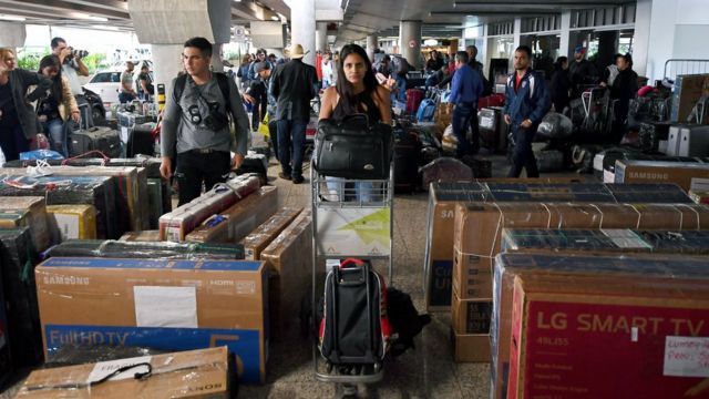 En una terminal, médicos cubanos cargan maletas y paquetes de viaje