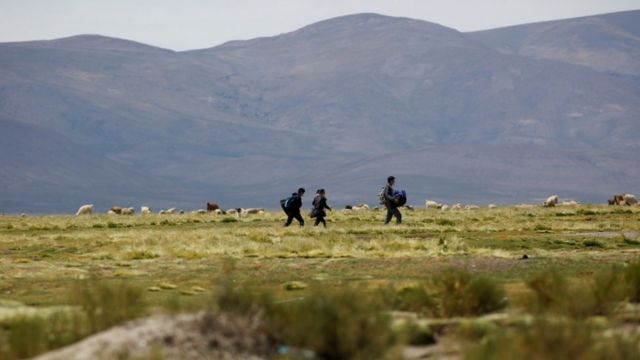 Migrantes venezolanos caminan por el desierto en el límite entre Bolivia y Chile.