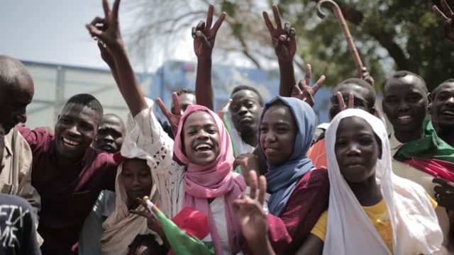 A crowd celebrates outside a venue in Sudan's capital, Khartoum, where generals and protest leaders signed a historic transitional constitution meant to pave the way for civilian rule in Sudan - August 2019