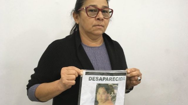 Marta Torres Castelo Branco segura cartaz com a foto da filha Eliene, que desapareceu em 2013, com 36 anos.