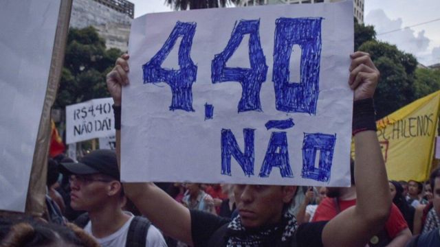 Homem segura cartaz que diz '4,40 não' em protesto contra reajuste de ônibus em São Paulo