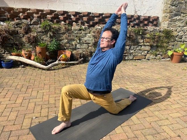 Ian Vollum does a yoga pose on his matt
