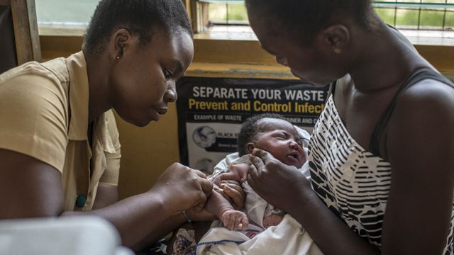 A nurse vaccinates a baby against malaria in Ghana in 2019