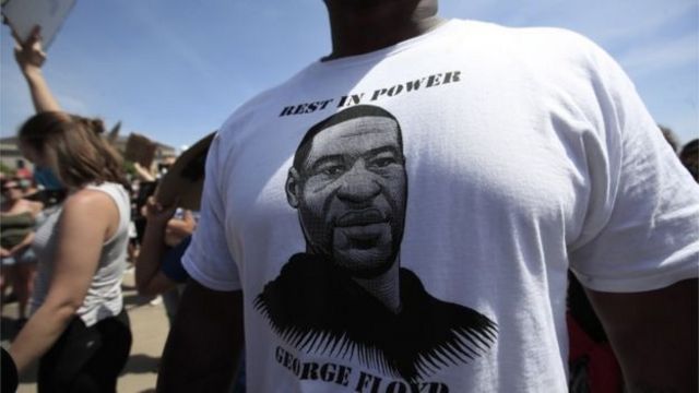 Protestocular George Floyd'un resmiyle basılmış tişörtler giyiyor