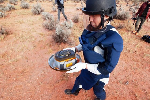 A member of the research team holds the container with samples taken from the asteroid Ryugu