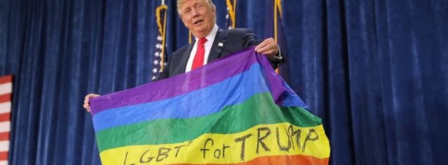 دونالد ترامپ با پرچم رنگین کمانی در دست که روی ان نوشته شده جامعه دگرخواهان جنسی حامی ترامپ