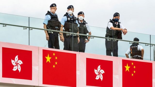 身穿防刺背心的香港警员在九龙尖沙咀沿着维多利亚港海旁站岗（1/7/2022）
