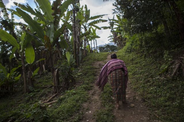 Catarina Mejía sube por un camino de tierra hacia su casa en Xeputul II, Guatemala