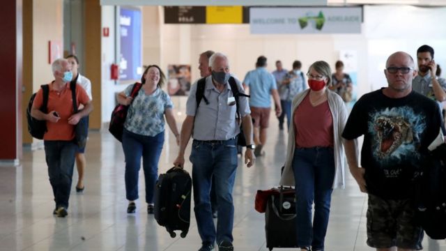 Passengers wearing masks walk through Adelaide Airport