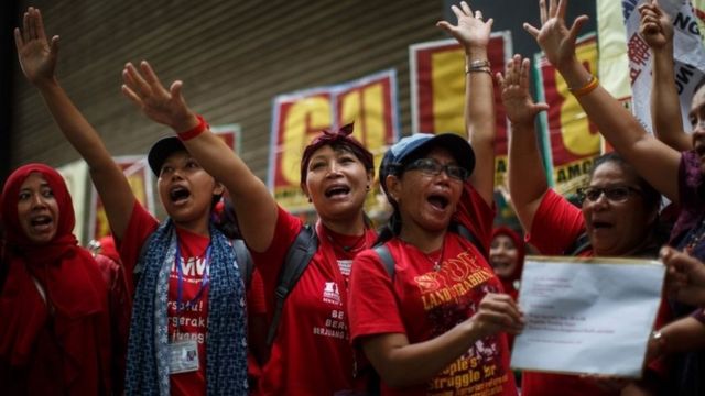 Domestic helpers gesture as they chant in support of being paid 5000 HKD per month during in a protest in Hong Kong on September 4, 2016