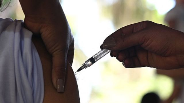 Vacina sendo aplicada num braço