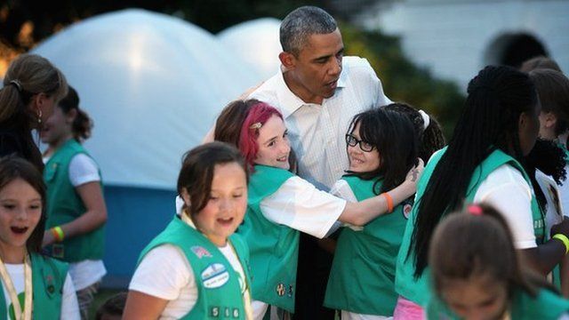 President Barack Obama hugs girl scouts on the South Lawn