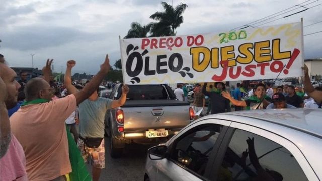 Protesto de caminhoneiros em refinaria de Duque de Caxias, no Rio, em 2018. com faixa contra o aumento do preço do diesel