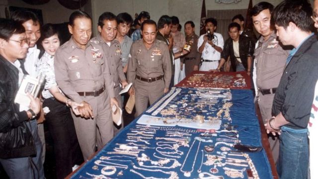 Tajlandska policija izložila je deo nađenog dragog kamenja. Kriangkraj stoji sa desne strane sa lisicama na rukama