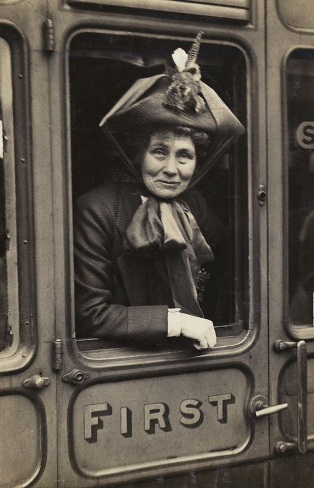 Emmeline Pankhurst por volta de 1910 sorri da janela do trem
